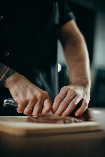Man Slicing Food on a Board