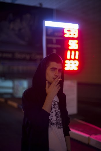 Man smoking a cigarette on the street at night  