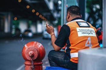 man smoking beside fire hydrant