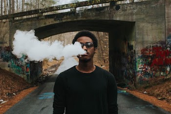 Man Smoking Near Bridge