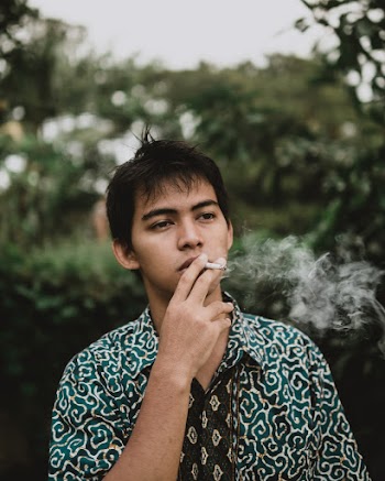 Man Smoking Near Trees