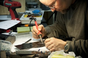 Man Soldering Circuit Board