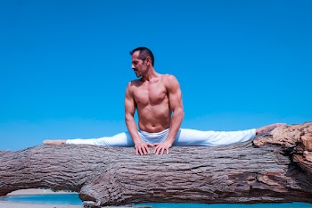 Man Splitting Legs on Brown Wood Log