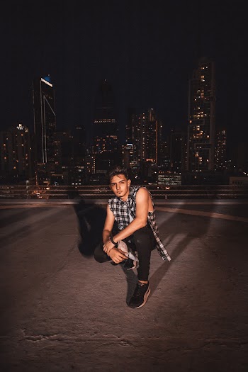 Man Squatting On Concrete Pavement