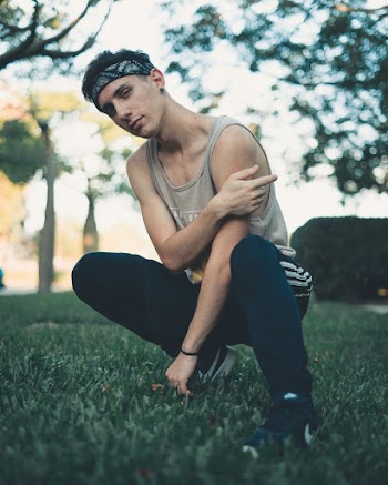 Man Squatting on Green Grasses