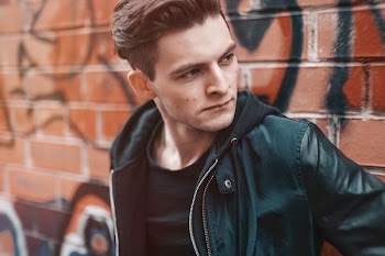 man standing against brown wall
