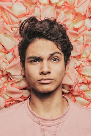 man standing against petaled flowers