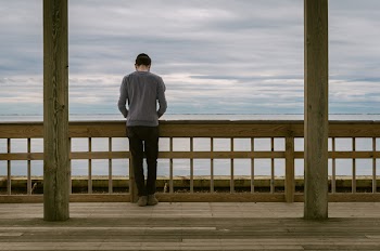Man Standing at Front of Wooden Fence