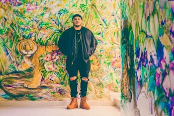 man standing behind assorted-design graffiti