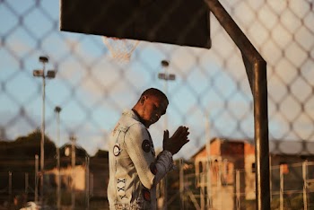 Man Standing Behind Fence