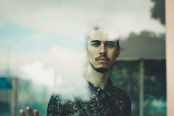 Man Standing Behind Glass Panel