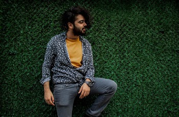 Man Standing Behind Grass Wall