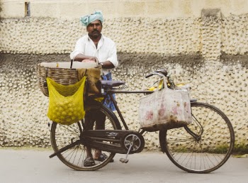Man Standing Behind His Bicycle in Front of Concrete Wall