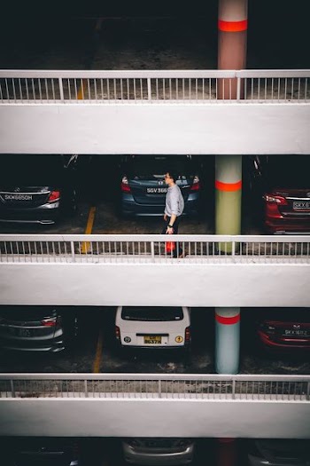 man standing behind vehicles