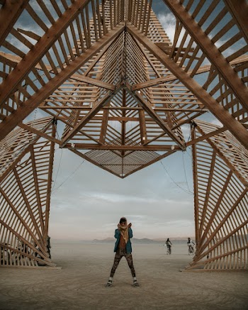 Man Standing Below A Wooden Structure