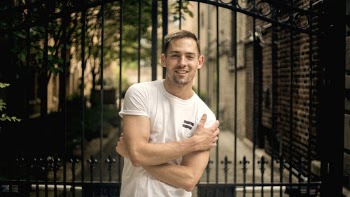 Man Standing Beside Black Gate