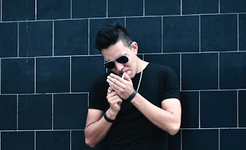 Man Standing Beside Black Wall
