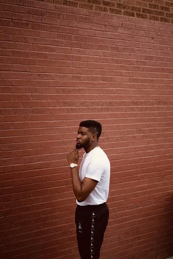 Man Standing Beside Brick Wall