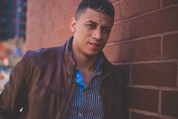 Man Standing Beside Brown Brick Wall