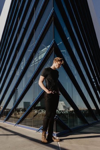 man standing beside building