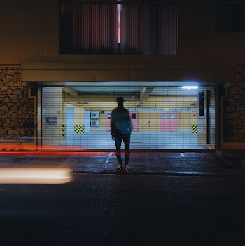 Man Standing Beside Building at Night