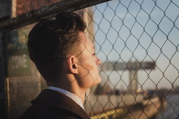 Man Standing Beside Chainlink Fence