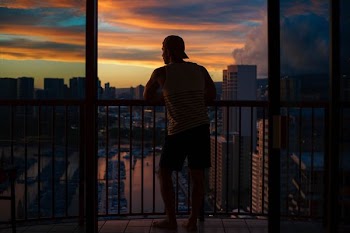 man standing beside gray metal grill taken at daytime
