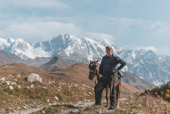 Man Standing Beside Horse