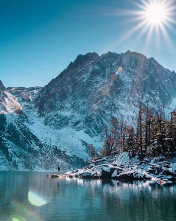 man standing beside of the lake