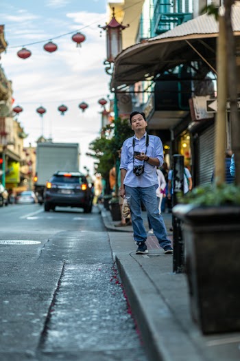 Man Standing Beside Street and Building