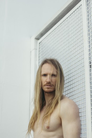 Man Standing Beside White Wall
