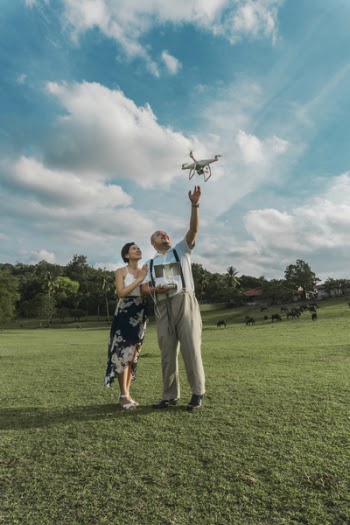 Man Standing Beside Woman Playing Drone