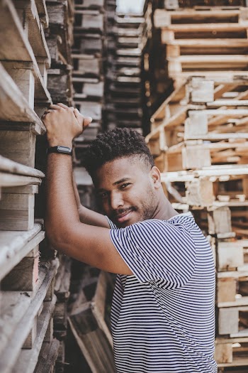Man Standing Beside Wooden Pallet