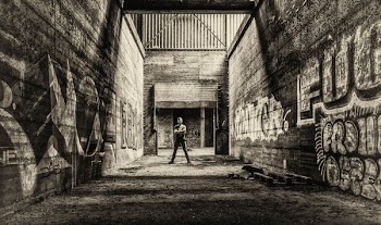 Man Standing Between Gray Concrete Walls