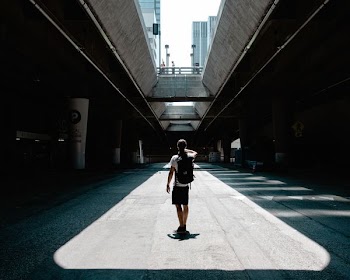 man standing between roads