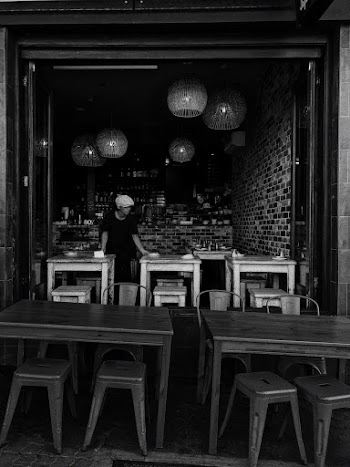 Man Standing Between Tables