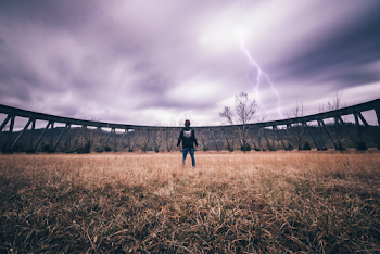 Man Standing by Elevated Train Track