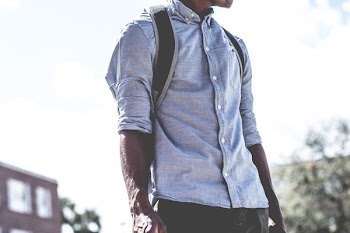man standing carrying backpack