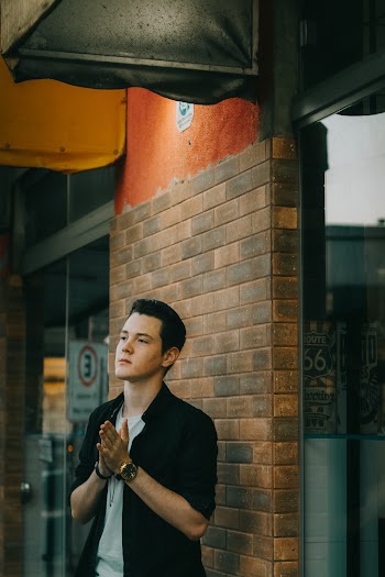 Man Standing Front of Bricks Wall