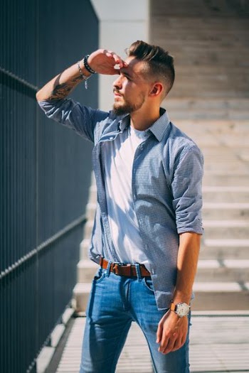 man standing in front of black steel fence during daytime