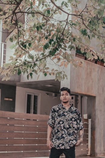 Man Standing In Front of Brown Building