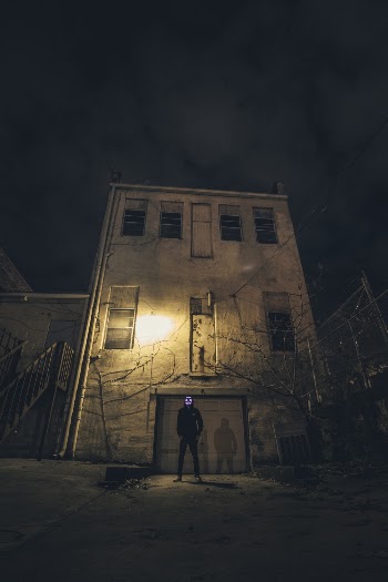 Man Standing in Front of Building during Nighttime