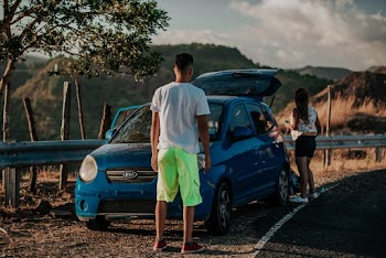 Man Standing in Front of Car Near Woman
