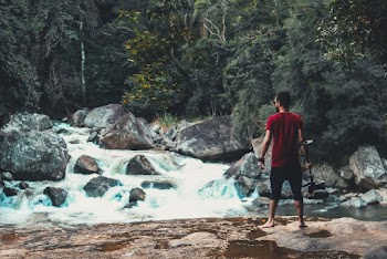 Man Standing In Front Of Flowing River