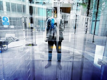Man Standing in Front of Glass Door and Taking Selfie