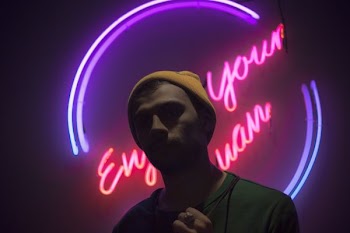 man standing in front of neon light signge