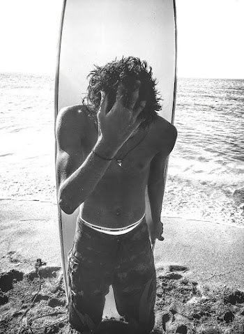 Man Standing in Front of Surfboard at the Shore during Day