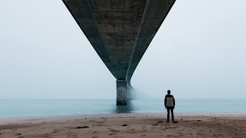 man standing in front of the bridge
