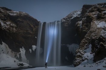 man standing in front of the waterfalls