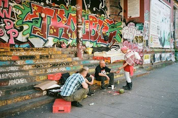 Man Standing in Front of Three Men Sitting on Stairs